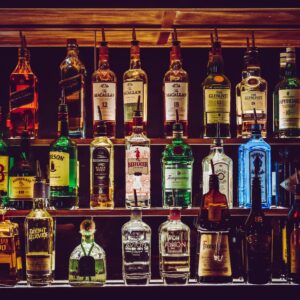 An array of various liquor bottles beautifully displayed on a bar shelf.